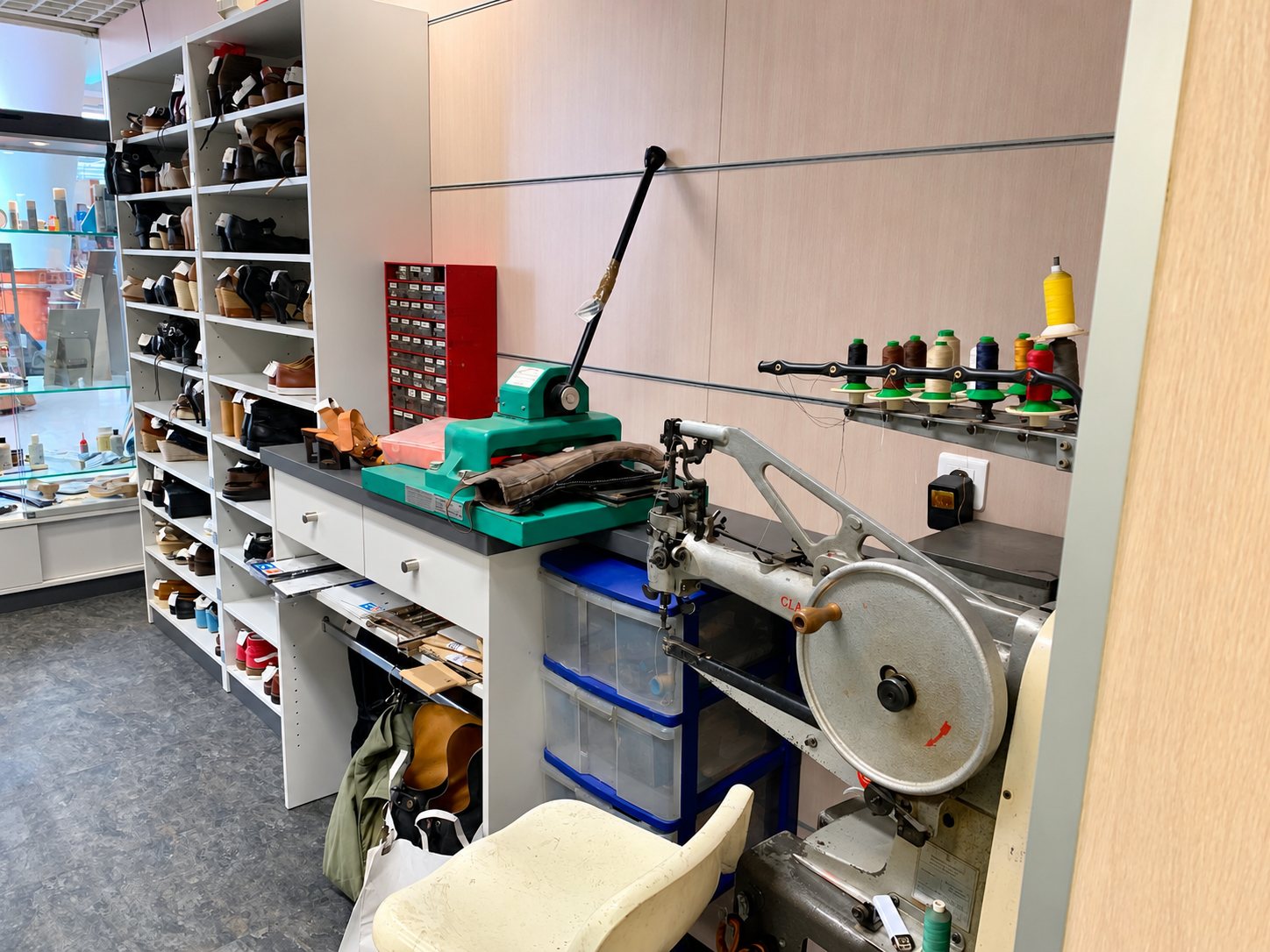 Atelier de cordonnerie avec machine à coudre et étagères de chaussures
