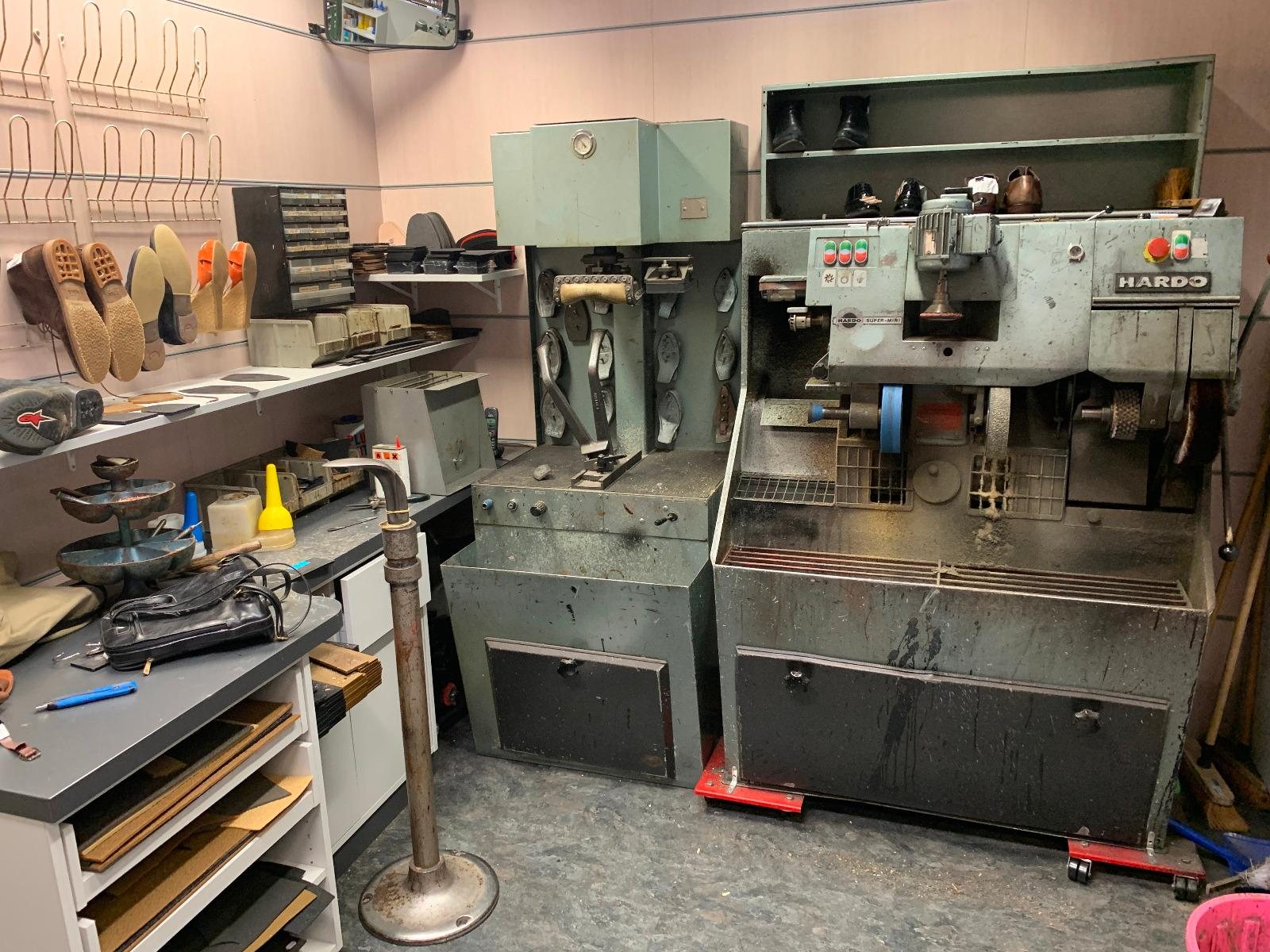 Atelier de cordonnerie avec machines anciennes et semelles de chaussures exposées