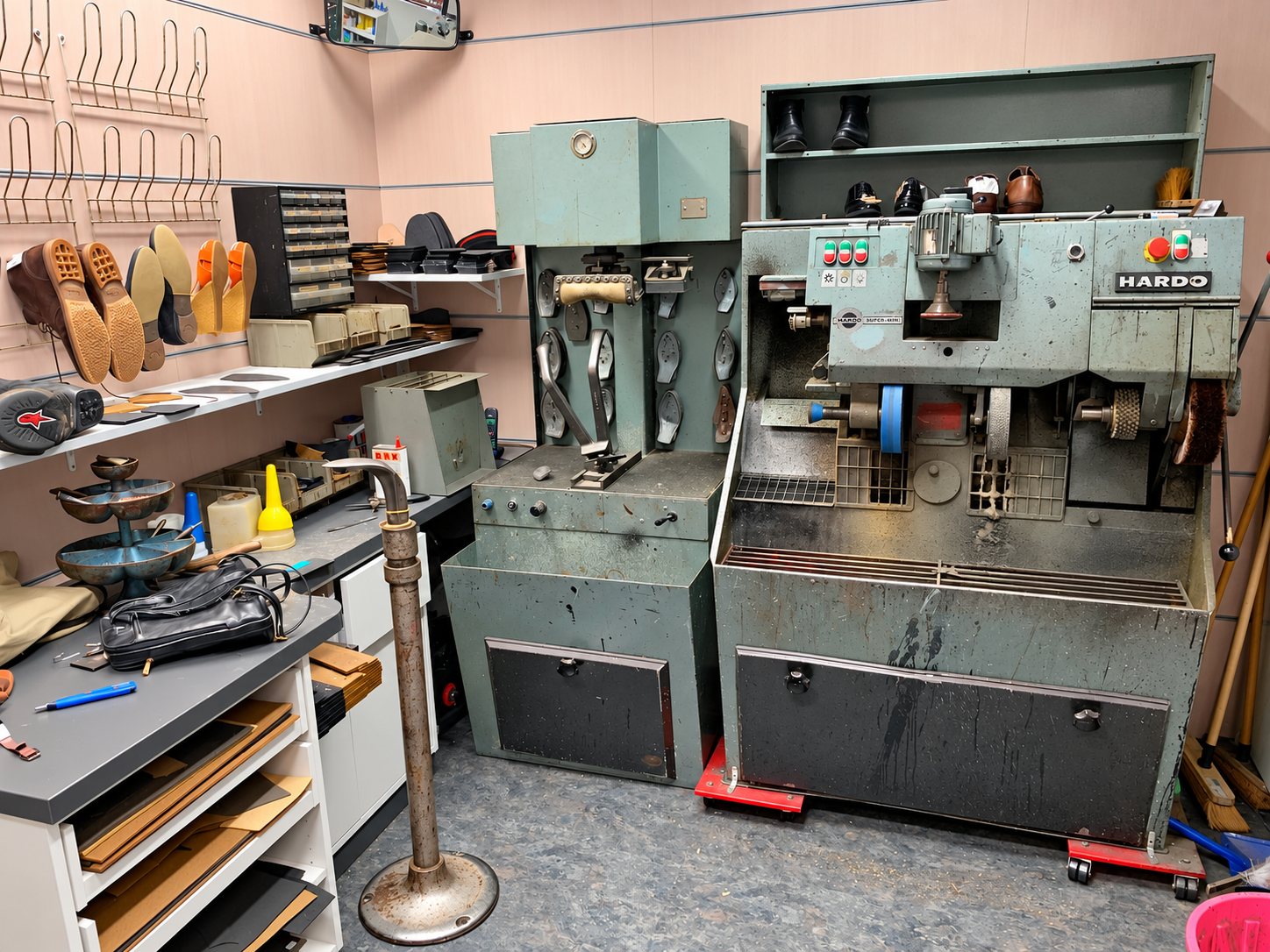 Atelier de cordonnerie avec machines anciennes et semelles exposées