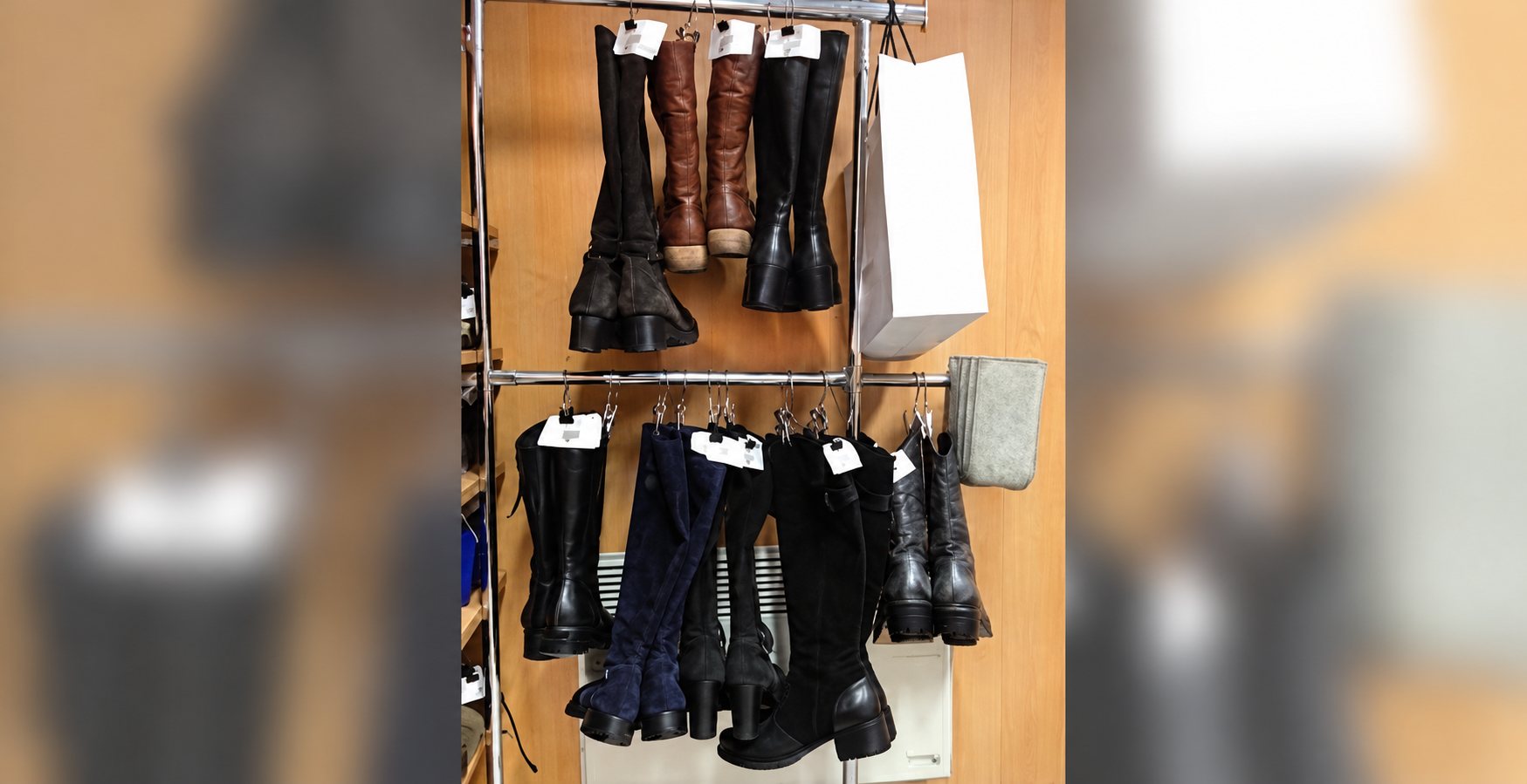Bottes en cuir suspendues sur des barres dans une boutique de chaussures