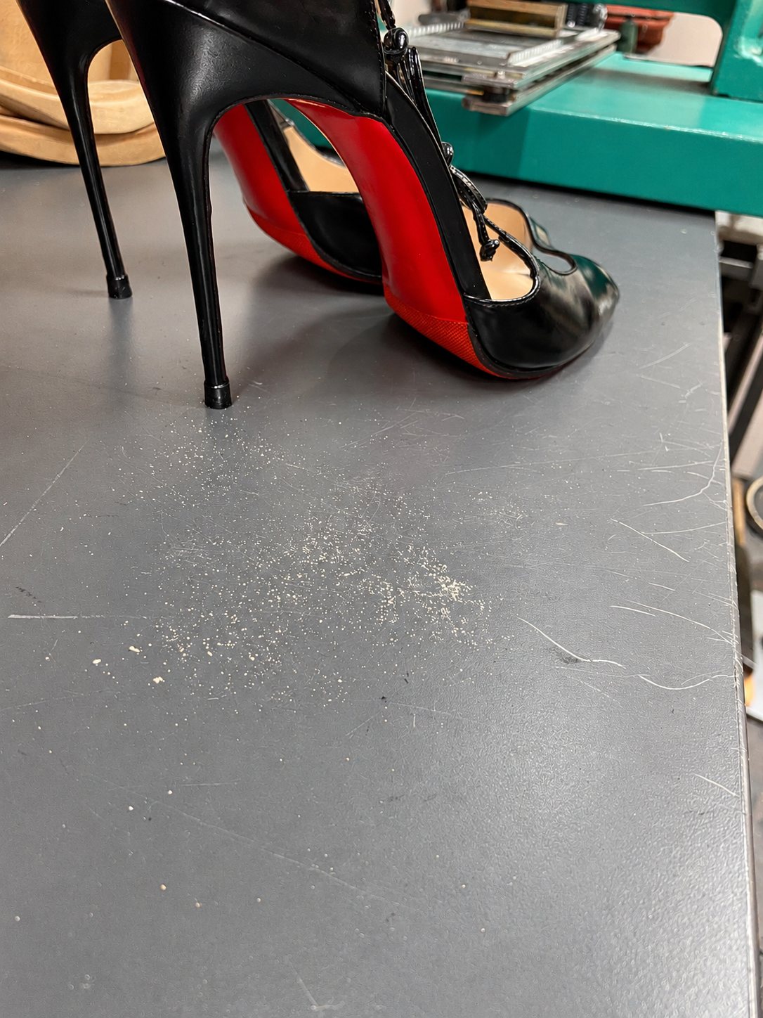 Escarpins noirs à talons aiguilles et semelles rouges sur un établi